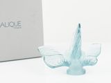 a glass bird that is sitting in front of a box