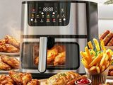 une grande friteuse à air chaud posée sur une table sur laquelle se trouvent de nombreux plats