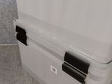 a large white cooler sitting on the floor next to a wall