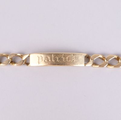 un gros plan d'un bracelet en or sur lequel est gravé un prénom