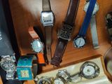 a lot of watches on a wooden table with a box
