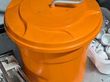 un seau orange posé sur un plateau en métal