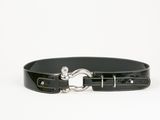 la ceinture est noire et est munie d'une boucle en métal