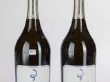deux bouteilles de vin posées l'une à côté de l'autre sur une table