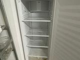 an image of an empty refrigerator in the corner of a room