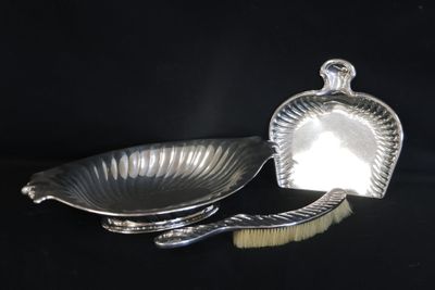 deux plats plaqués argent et une brosse sur fond noir