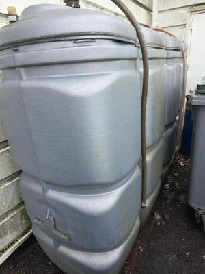 un grand réservoir muni d'un tuyau, situé à côté de quelques poubelles