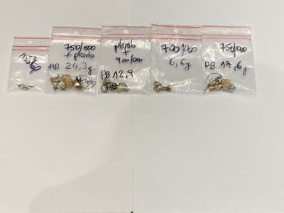 three bags of small metal animals sitting on top of a white surface