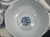 a white bowl with a blue flower on it next to other dishes