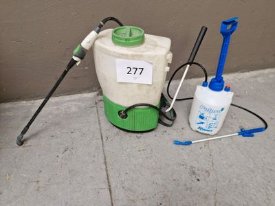 un pulvérisateur vert et blanc posé sur le trottoir à côté d'un pulvérisateur bleu et blanc