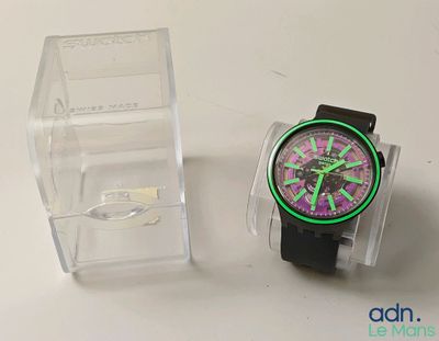 une montre posée à côté d'une boîte transparente