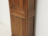 a tall wooden cabinet in the corner of a room