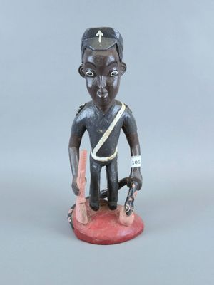 figurine représentant un homme tenant un couteau dans une main et un autre couteau dans l'autre