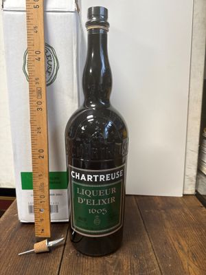 une bouteille d'alcool posée sur une table à côté d'une règle