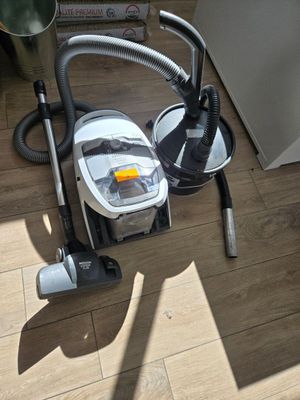 a vacuum that is sitting on the floor next to a bowl