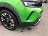a close up of a green suv parked in a parking lot
