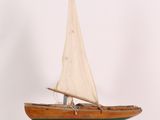 a small wooden sailboat on a stand on a white background