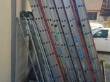 a pile of skis leaning against the side of a building