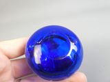 une personne tenant une boule de verre bleue dans la main