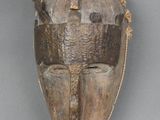 une image d'un masque en bois accroché au mur