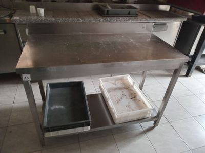 a kitchen island with a sink and a trash can on it