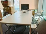 une table blanche avec des chaises et un ordinateur posé dessus