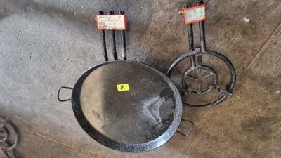 two pots and pans hanging on the wall next to each other