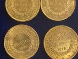 four gold coins with the names of different countries on them