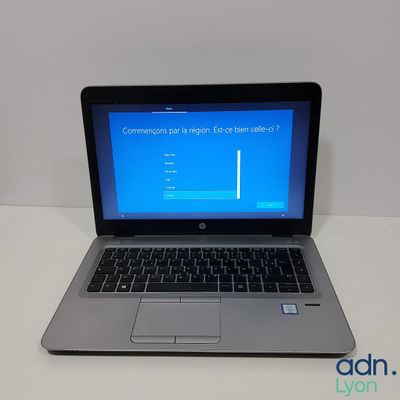 a laptop computer sitting on a table with a blue screen