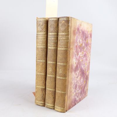trois vieux livres sont empilés sur une table