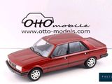 a red toy car that is sitting on a white surface