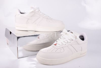 une paire de baskets blanches posée sur une boîte