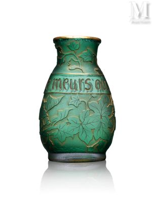 un vase vert posé sur une surface blanche, sur fond blanc