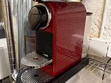 une machine à café rouge posée sur une étagère dans une cuisine