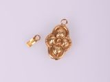 un pendentif plaqué or orné d'un motif floral