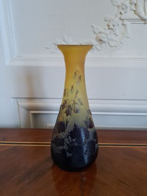 a yellow and black vase sitting on a wooden table