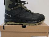 une paire de chaussures de randonnée noires posée sur une boîte en carton