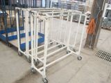 un chariot en métal blanc muni de roues, dans un entrepôt