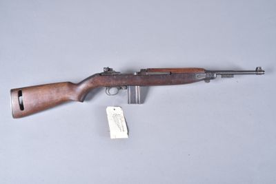 the rifle is laying on the table with a tag on it
