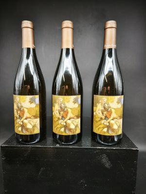 trois bouteilles de vin posées sur un bloc de bois