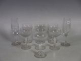 several empty wine glasses are lined up on a white surface