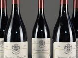 six bouteilles de vin rouge sont alignées sur une table