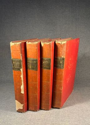 three red books are stacked on top of each other on a gray surface
