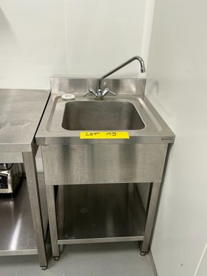 un évier en inox et un plan de travail en inox dans une petite cuisine