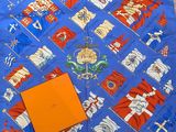 un gros plan sur une écharpe bleue sur laquelle figure une boîte orange