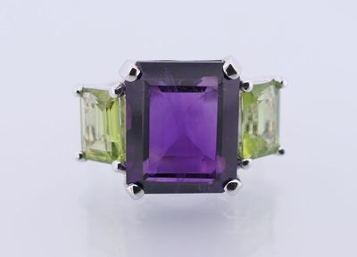 a close up of a ring with an amethorate and green amethorate