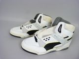 une paire de baskets blanches et noires avec des touches de noir sur une base grise