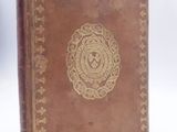 a brown leather book with a gold medallion on the cover