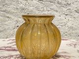 un vase jaune posé sur une table recouverte d'une nappe rouge et blanche