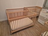 a baby crib in the corner of a room with a dresser next to it